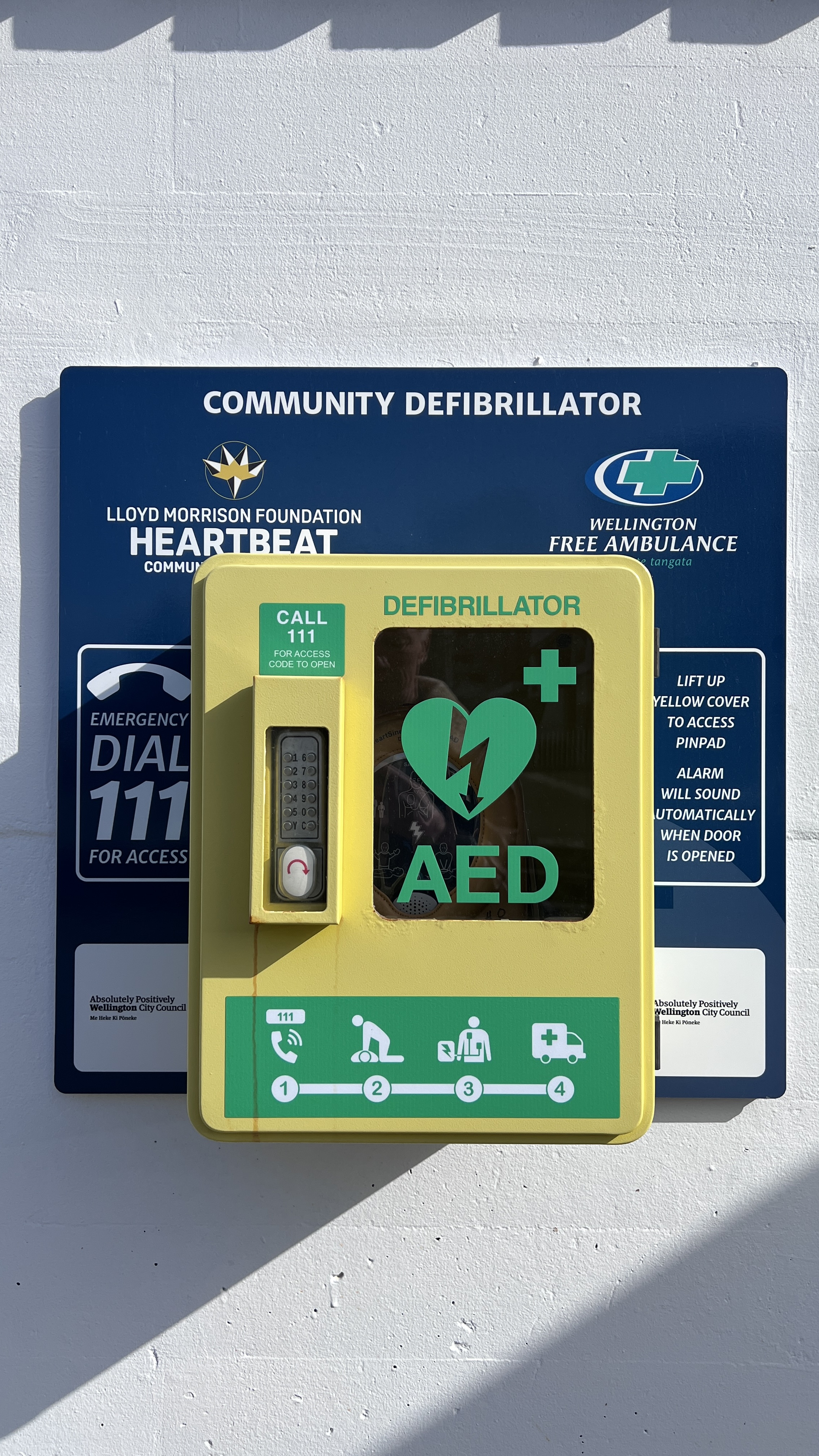 A community automated external defibrillator mounted on a wall.